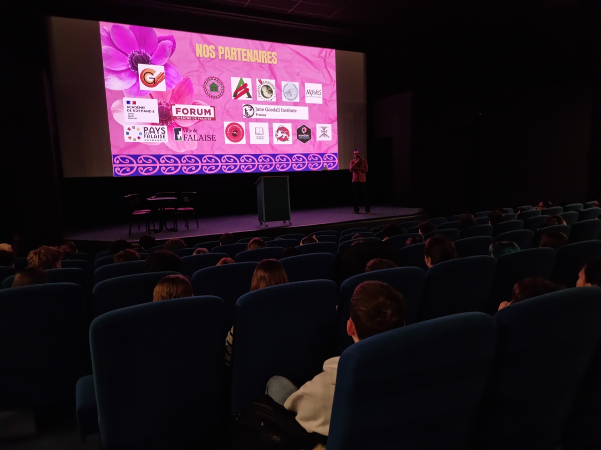 Vue de la salle de cinéma pendant le forum de Falaise, avec Benjamin Combes sur scène devant un écran affichant les partenaires de l’événement.