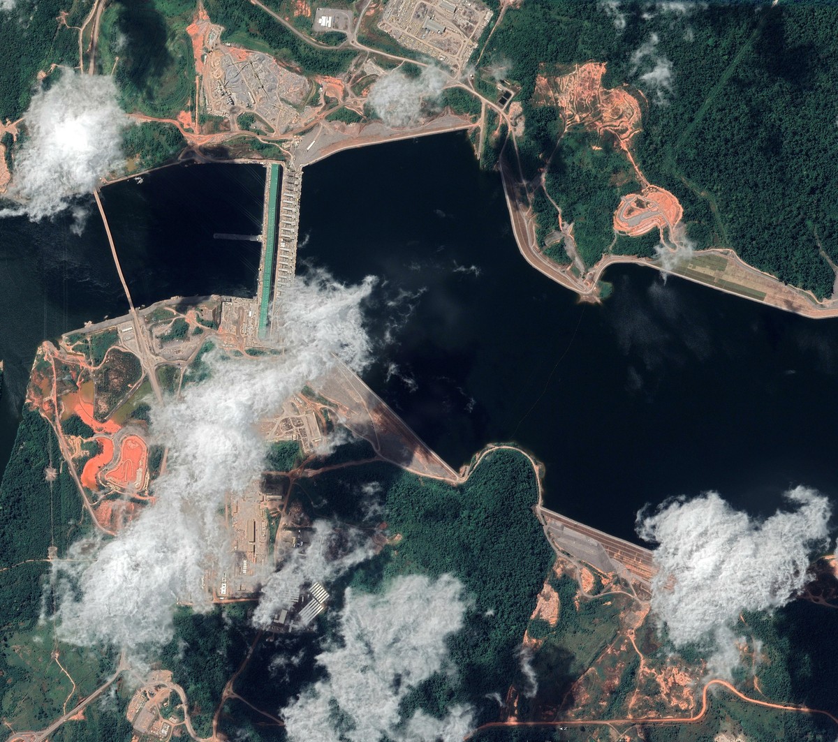 Vue aérienne du complexe hydroélectrique de Belo Monte, avec le barrage, les retenues d’eau, les routes et les zones défrichées alentour.
